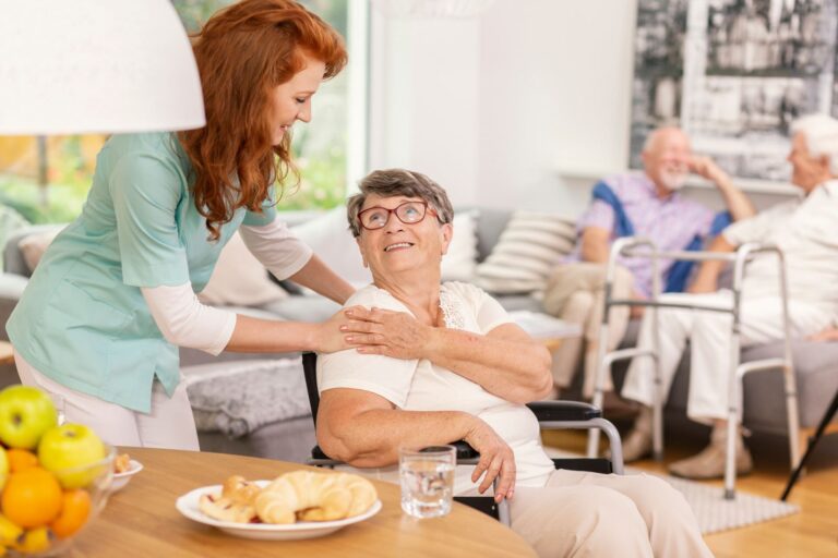 Eine ältere Dame, die von einer Pflegekraft umsorgt wird.